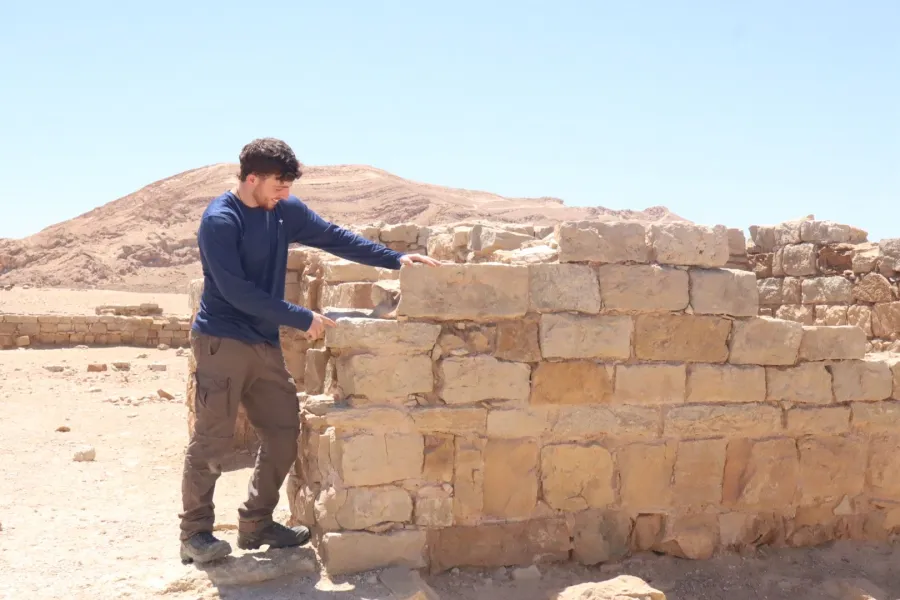 גיא, מדריך הטיולים של קאימאק, ליד חומת אבן עתיקה במדבר