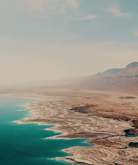 צילום אוויר של חוף ים המלח ושכבות הסלע לידו